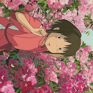 May include: A young girl with brown hair lies in a bed of pink flowers. She is wearing a pink robe and has a surprised expression on her face.