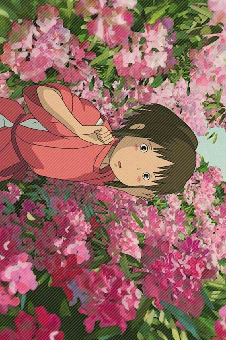 May include: A young girl with brown hair lies in a bed of pink flowers. She is wearing a pink robe and has a surprised expression on her face.