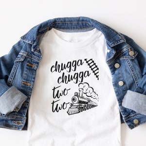 May include: White t-shirt with a black and white illustration of a train and the text "chugga chugga two two".