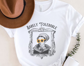 May include: White t-shirt with a black and white illustration of a person wearing sunflower sunglasses. The text "Barely Tolerable" is above the illustration.
