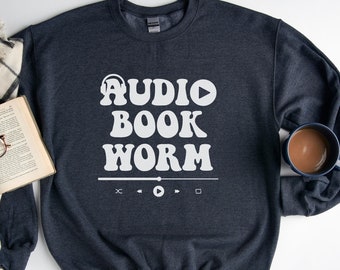 May include: Dark gray sweatshirt with white text that reads "AUDIO BOOK WORM" in a retro font. Below the text is a white play button and other media controls.