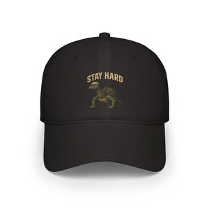 Puede incluir: Gorra de béisbol negra con una tortuga de dibujos animados que lleva un gorro de marinero y el texto "Stay Hard".