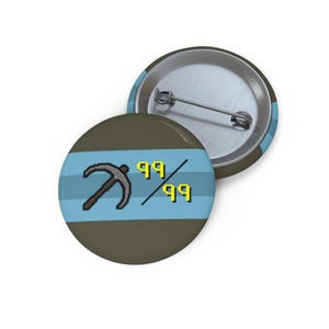 Puede incluir: Dos botones redondos con un gráfico de pico y los números "99/99" en amarillo. Los botones tienen una combinación de colores azul y gris, con una franja azul claro en el centro. Los botones son probablemente para un juego o pasatiempo.