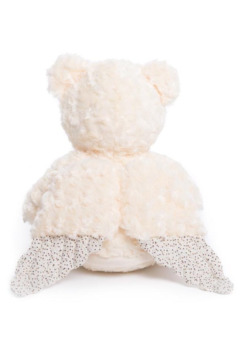 Op de afbeelding: Cr&egrave;mekleurige pluche teddybeer met een getextureerd lichaam en kleine oren. De poten van de beer zijn versierd met witte stof met een zwart stippenpatroon. Het speelgoed is ontworpen voor comfort en spel.
