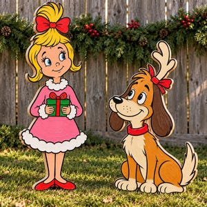 May include: A wooden cutout of a blonde girl with a red bow holding a green gift with a red ribbon, standing next to a wooden cutout of a brown dog with floppy ears, a red collar, and a single antler headband with a red bow.