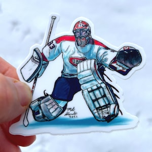 May include: A cartoon illustration of a hockey goalie wearing a white jersey with red and blue accents, a red helmet and holding a hockey stick. The goalie is in a defensive position, with one leg bent and the other extended. The goalie's glove is raised in the air, and the goalie's stick is pointed towards the ground. The illustration is on a white background.