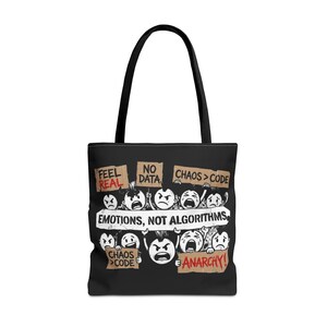 May include: Black tote bag with a graphic design featuring cartoon faces holding signs with phrases like "Feel Real," "No Data," and "Chaos > Code." The text "Emotions, Not Algorithms" is also displayed.