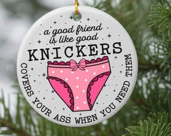 May include: A white ceramic Christmas ornament with a gold string, featuring a pink polka-dot underwear graphic. Text reads "a good friend is like good KNICKERS covers your ass when you need them."