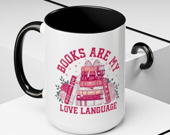 May include: White ceramic mug with a black handle and interior. The mug features the text "BOOKS ARE MY LOVE LANGUAGE" in pink, along with a stack of books and floral accents. A perfect gift for book lovers.