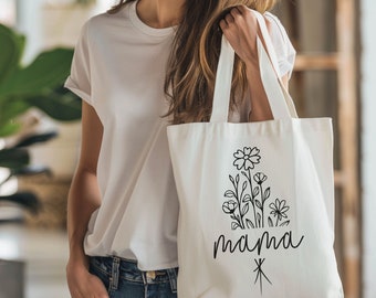 May include: A white tote bag with black floral designs and the word "mama" printed on it.