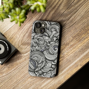 May include: A black and white phone case with a detailed, intricate design of swirling patterns and shapes. The case has a camera cutout with three lenses.