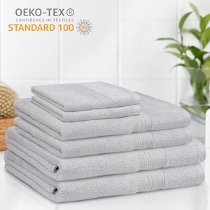 May include: A stack of six gray bath towels. The towels are made of soft, absorbent cotton and are certified Oeko-Tex Standard 100, meaning they are free of harmful chemicals.