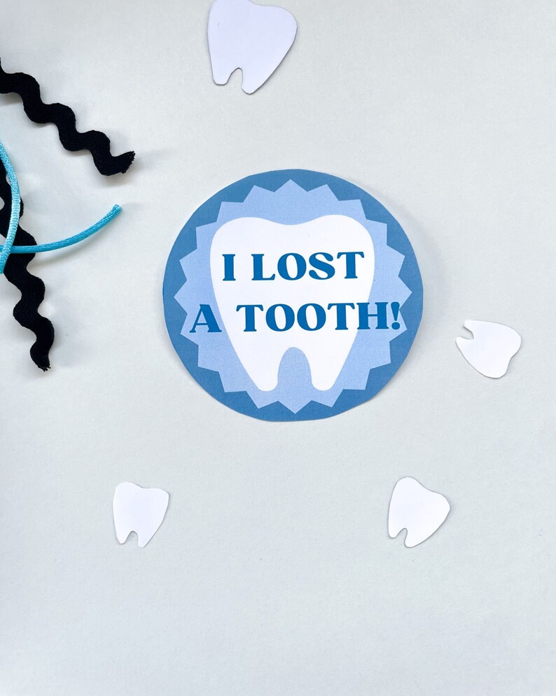 May include: A blue and white circle with a tooth graphic and the text "I lost a tooth!" on a white background. There are five white tooth shapes scattered around the circle.