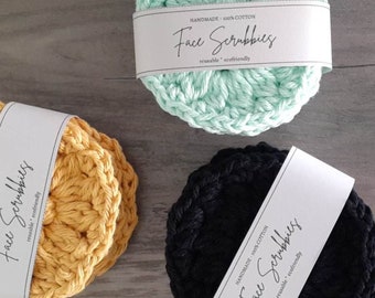 Peut inclure: Trois éponges à récurer le visage en crochet de couleur verte, jaune et noire. Chaque éponge est dotée d'une étiquette blanche sur laquelle est inscrit "HANDMADE - 100% COTTON Face Scrubbies reusable ecofriendly".