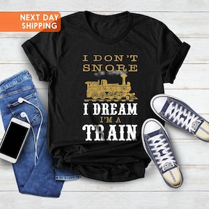 May include: Black t-shirt with a gold graphic of a train and the text "I don't snore I dream I'm a train".