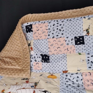 Peut inclure: Une couverture b&eacute;b&eacute; beige avec un motif patchwork sur le th&egrave;me nautique. La couverture est faite d'un tissu doux et pelucheux et a une texture matelass&eacute;e. Le motif patchwork comprend divers motifs, tels que des ancres, des bateaux et des &eacute;toiles. La couverture est parfaite pour c&acirc;liner et garder les b&eacute;b&eacute;s au chaud.