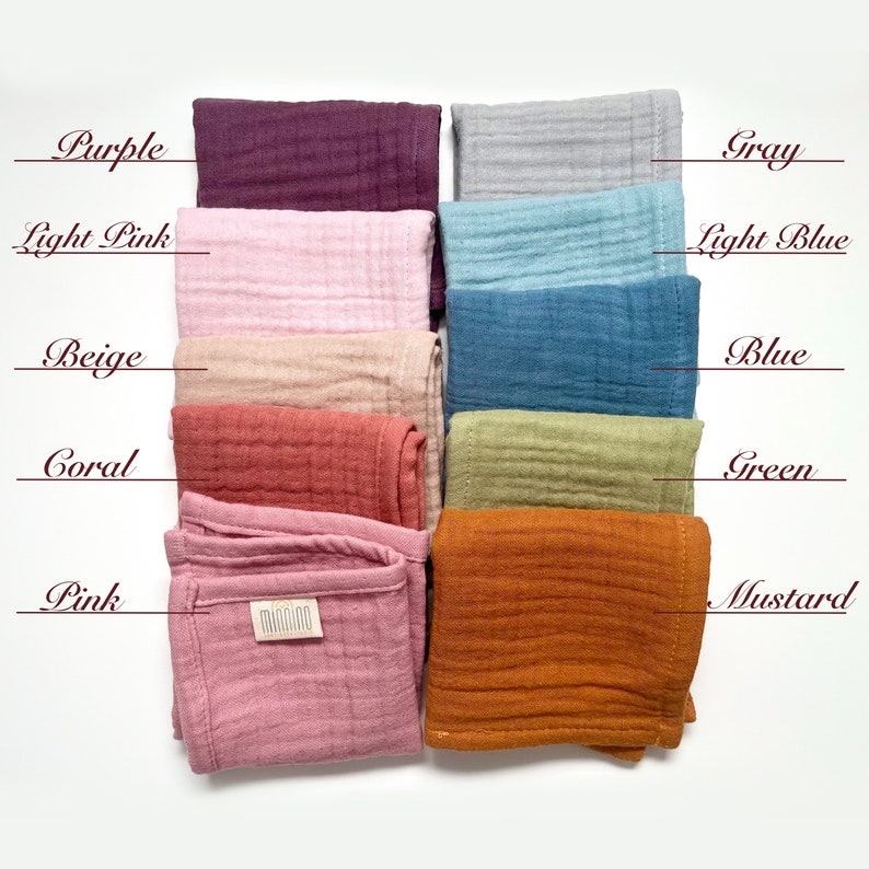 May include: Ten squares of fabric in different colors, including purple, light pink, beige, coral, pink, gray, light blue, blue, green, and mustard. The fabric is a soft, textured muslin.