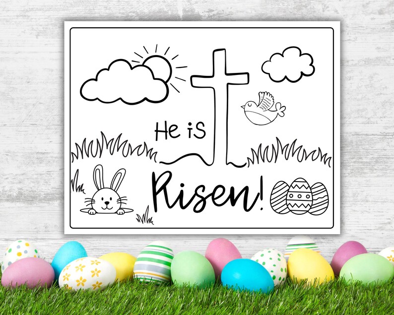 May include: Black and white coloring page with a cross, a bird, clouds, a sun, grass, a bunny, and Easter eggs. The text says "He is Risen!"