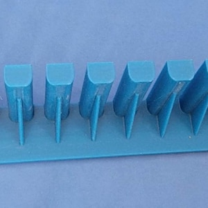 May include: A light blue plastic organizer with 15 slots for holding small items. The organizer is designed to be mounted on a wall.
