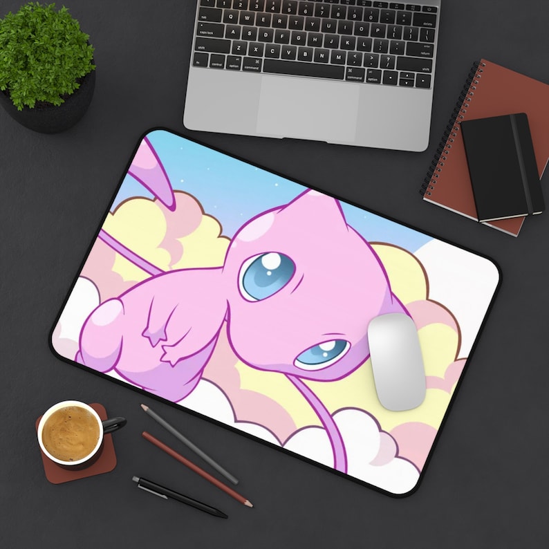 May include: A pink and blue mousepad with a cartoon image of a pink and blue Pokemon character with a long tail. The character is flying in the clouds.