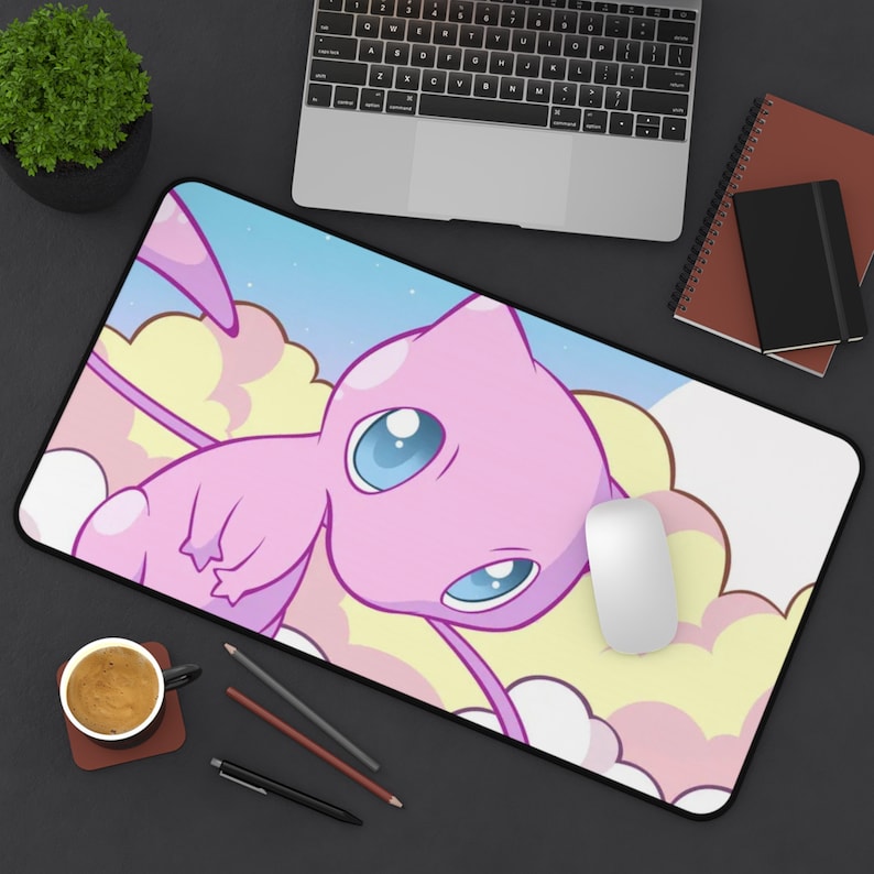 May include: A pink and white mousepad with a cartoon image of a pink, flying, mythical creature with blue eyes. The creature is surrounded by clouds and stars.
