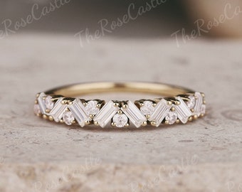 May include: A delicate gold band with a chevron pattern of baguette and round diamonds.