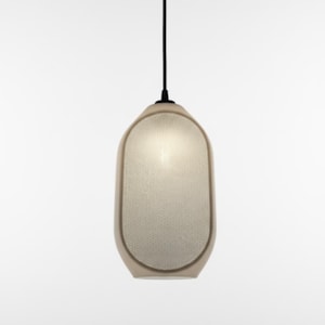 Könnte beinhalten: Eine moderne Pendelleuchte mit beigefarbenem, ovalem Schirm. Der Schirm hat ein strukturiertes, perforiertes Design und hängt an einem schwarzen Kabel. Die Leuchte ist für den Innenbereich konzipiert und bietet Umgebungslicht.