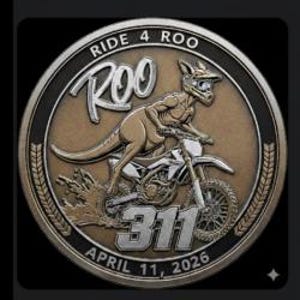May include: A circular, bronze-coloured coin depicting a kangaroo on a motorbike. The coin is inscribed with "RIDE 4 ROO" and "ROO" in a decorative font. The number "311" and the date "APRIL 11, 2026" are also present.