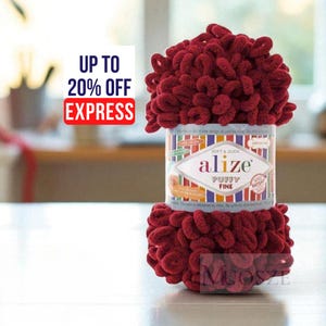 Puede incluir: Un ovillo de lana Alize Puffy Fine de color rojo oscuro. El hilo es suave y rápido de trabajar, ideal para diversos proyectos de manualidades. La etiqueta muestra "Alize Puffy Fine" y "Soft & Quick".