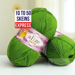 May include: Three skeins of bright green yarn, labeled "Alize Cotton Gold." The yarn is tightly wound into balls, with a purple and white label wrapped around each. Text on the label reads "10 to 50 Skeins Express."