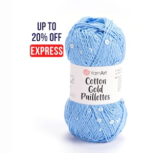 May include: A light blue ball of YarnArt Cotton Gold Paillettes yarn with white sequins. The label reads "Cotton Gold Paillettes" and "Express". The ball weighs 50g. The text "Up to 20% Off" is also visible.