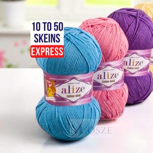 May include: A row of colorful yarn skeins in shades of blue, pink, purple, and yellow. Each skein is labeled "alize Cotton Gold." The image includes text that reads "10 to 50 skeins express."