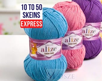 May include: A selection of Alize Cotton Gold yarn skeins in blue, pink, purple, and yellow. The image shows the text "10 to 50 skeins express." Each skein is labelled with the brand name. The yarn is suitable for knitting and crochet projects.