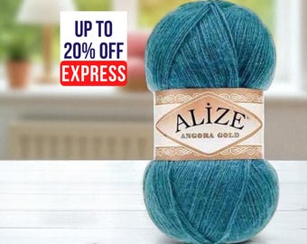 May include: A teal-colored ball of Alize Angora Gold yarn sits on a white surface. The yarn is wrapped with a label that reads "ALIZE ANGORA GOLD". The image also includes text that says "UP TO 20% OFF EXPRESS".