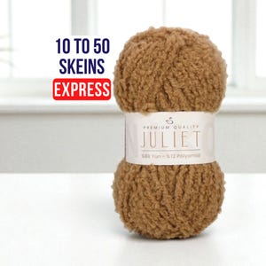 Puede incluir: Una madeja de lana Juliet marrón con una etiqueta blanca. La etiqueta dice "Premium Quality Juliet" y "88% Yün - 12% Polyamid." El texto encima de la lana dice "10 to 50 Skeins Express."