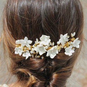 In this image you can see the head of the bride from behind with the white porcelain flower hairpiece