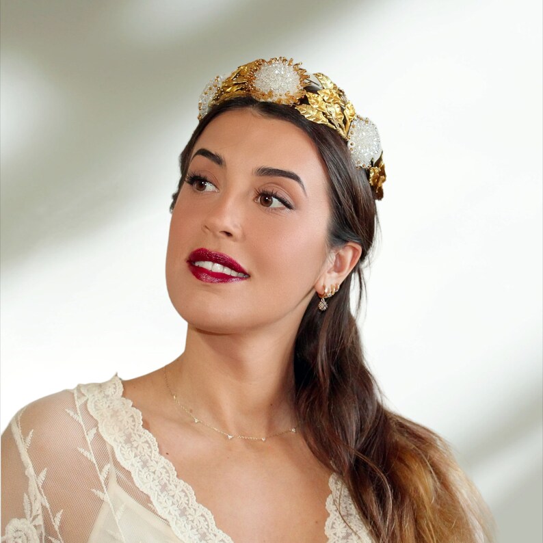 In this image we can see the bride with her bridal tiara crown with rhinestones, porcelain leaves and  golden colored crystals.