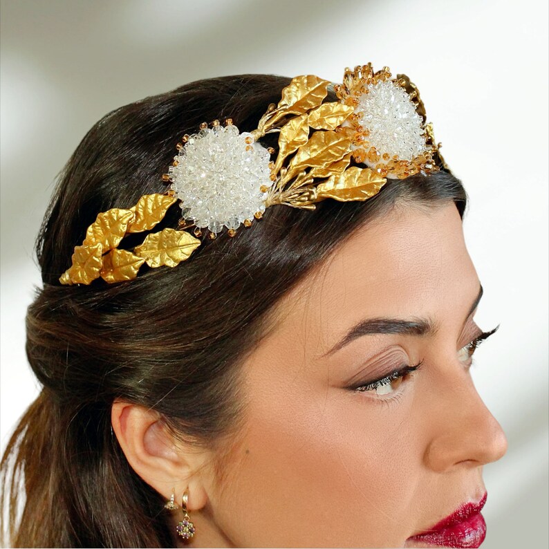 In this image we can see the bride head with her tiara crown with rhinestones, porcelain leaves and golden crystals.