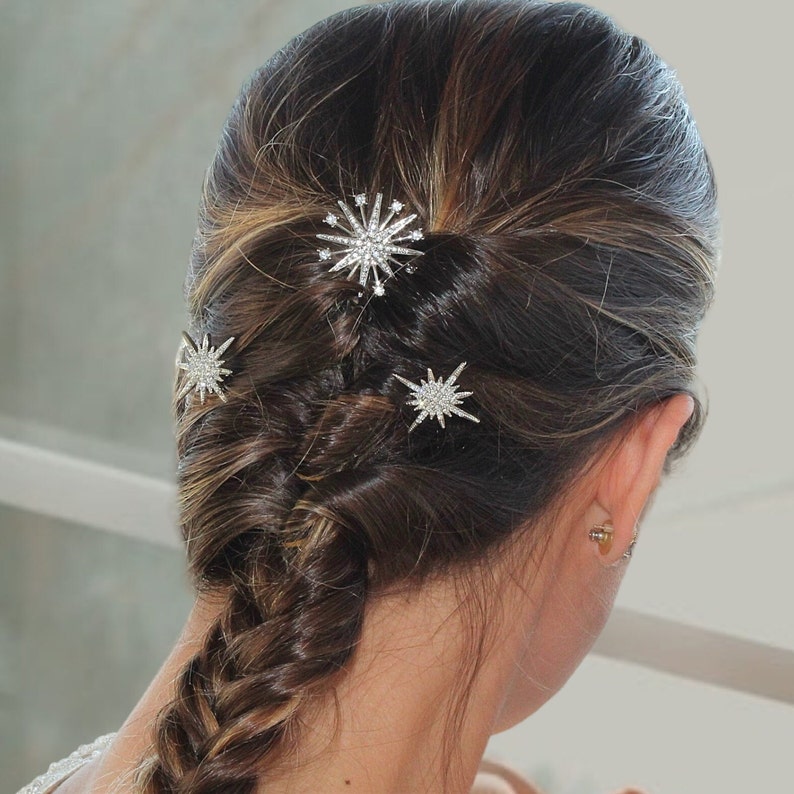 This image shows the bride with her dark hair tied back and 3 star hair pins on her head.