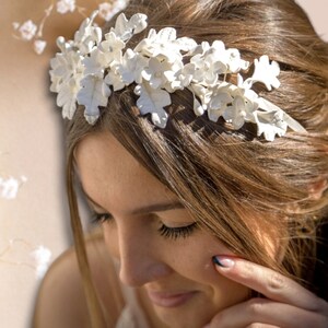 In this image we can see the bride with her handmade white porcelain flower and leaf tiara more closely in profile looking slightly downward.