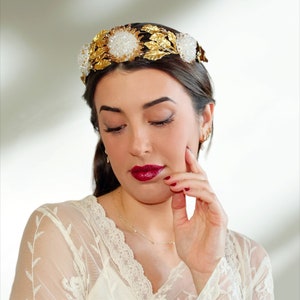 In this image we can see the bride with her bridal tiara crown with rhinestones, porcelain leaves and  golden colored crystals.