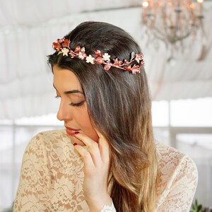 In this image we can see the bride with her crown of flowers and porcelain leaves in rose gold color while looking slightly downward