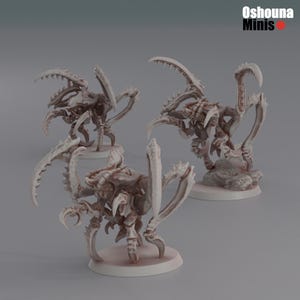 May include: Three gray, detailed, plastic miniature figures of alien creatures with multiple legs and claws. The figures are posed on circular bases.