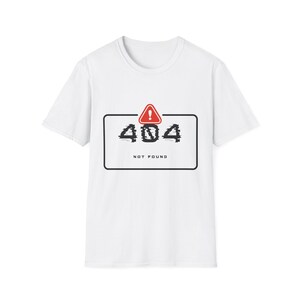 Könnte beinhalten: Weißes T-Shirt mit schwarzem, rechteckigem Rahmen. Darin die Zahl "404" im Glitch-Effekt, ein rotes Dreieck mit Ausrufezeichen und die Worte "NOT FOUND". Rundhalsausschnitt.