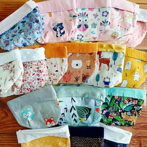 Peut inclure: Une collection de paniers de rangement en tissu avec divers motifs, notamment floraux, animaliers et géométriques. Les paniers présentent une variété de couleurs, telles que le rose, le bleu, le jaune et le vert, et sont disposés sur une surface en bois.
