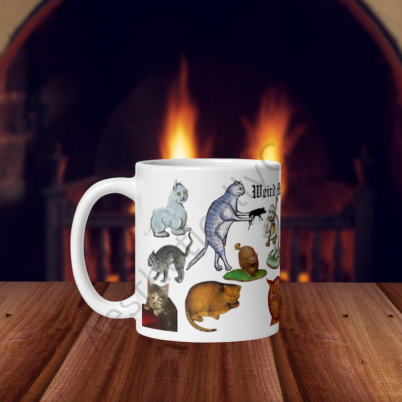 White ceramic coffee mug with full color illustrations of cats in medieval attire, engaging in humorous activities like playing instruments, holding mice, and making funny faces. Perfect gift for cat lovers with a sense of humor