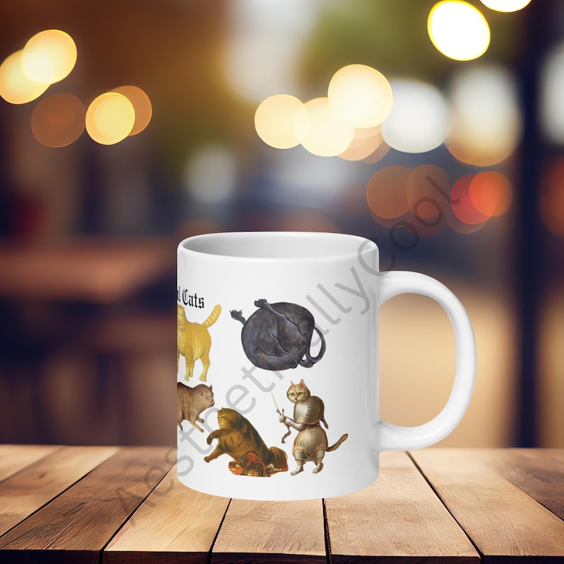 White ceramic coffee mug with full color illustrations of cats in medieval attire, engaging in humorous activities like playing instruments, holding mice, and making funny faces. Perfect gift for cat lovers with a sense of humor