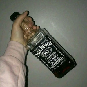 May include: A glass bottle of Jack Daniel's Tennessee Whiskey with a black label. The label has the brand name, "Old No. 7", "Sour Mash", "Whiskey", "70cl 40% Vol.", and "Tennessee".