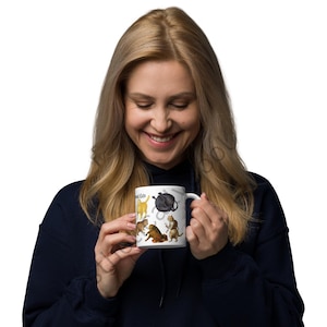 Happy lady holding White ceramic coffee mug with full color illustrations of cats in medieval attire, engaging in humorous activities like playing instruments, holding mice, and making funny faces. Perfect gift for cat lovers with a sense of humor
