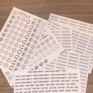May include: Sheets of stickers with various designs, including smiley faces, stars, and horseshoe shapes. Text on the stickers includes phrases like "What's going onnn???" and "Wait, what?!"